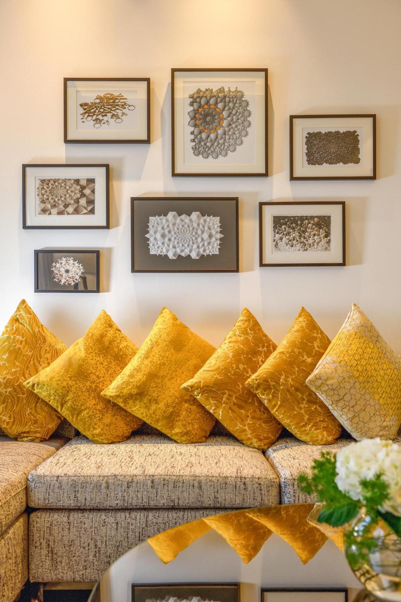 Grand Mercure Dubai City Hotel Exterior photo The photo showcases a cozy interior space featuring a row of vibrant yellow decorative cushions arranged along a bench or sofa. Above the cushions, there are several framed artworks displayed on the wall. The frames are in various styles, showcasing 